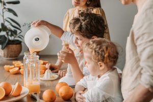 A family bonding over making fresh orange juice at home, enjoying quality time together.